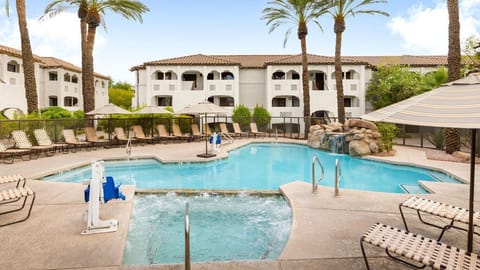 Unwind in the tranquil pool area, complete with a soothing hot tub and lush landscaping.