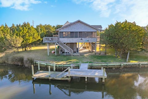Waterfront property features elevated beach house with private dock and peaceful canal access.