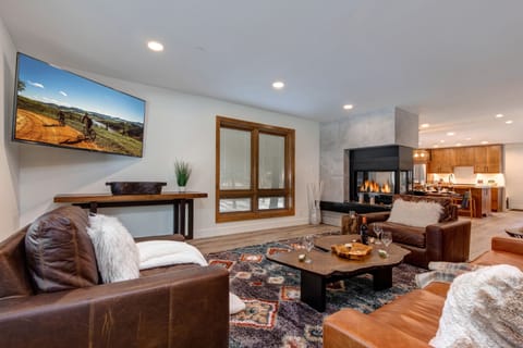 Living room with sleeper sofa, wet bar and beverage fridge, two-sided Gas Fireplace and 65" LG Smart TV