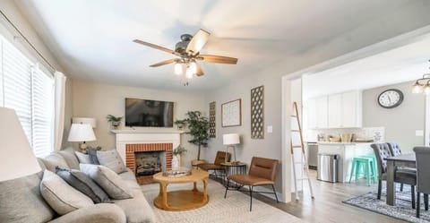 Enjoy this stylish open-concept living space featuring exposed brick walls, cozy seating, and a full entertainment setup, ideal for relaxing or gathering with friends and family.