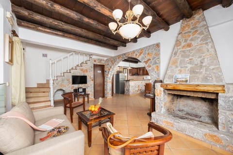 Open-plan living room with sofa, dining area, kitchen, indoor pool, ornamental fireplace, A/C, WiFi internet, and satellite TV