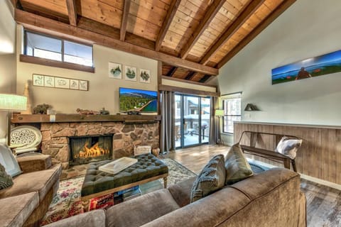 Unwind by your crackling fireplace beneath stunning exposed beams, where rustic charm meets modern comfort in this inviting living space.