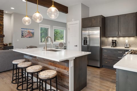 - Kitchen island with modern sink and pendant lighting for ambiance   - Open floor plan connecting dining and living spaces for gatherings   - Ideal setup for family cooking entertaining and Colorado stays