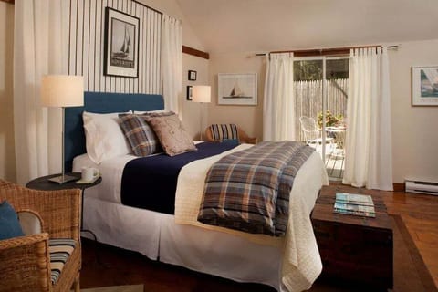 The Cottage queen bed and patio door to the rear garden courtyard which is surrounded by an 8 foot tall privacy fence.