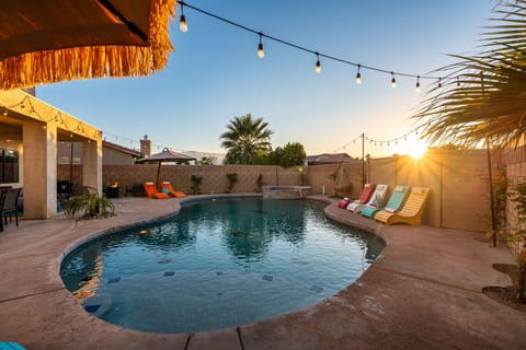 Pool side: large pool and spa, sun loungers with cantilever umbrellas, and outdoor fire pit