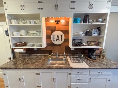 Modern and efficient—everything you need to create a delicious meal. The kitchen features a stainless steel refrigerator, stove, coffee maker, kitchenette oven, kettle, and blender