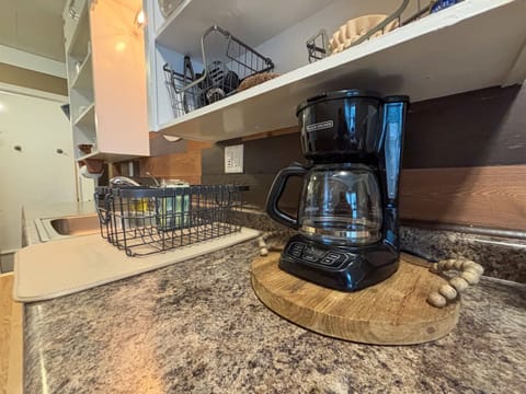 Modern and efficient—everything you need to create a delicious meal. The kitchen features a stainless steel refrigerator, stove, coffee maker, kitchenette oven, kettle, and blender