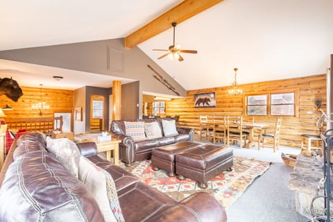 Unwind in your spacious cabin retreat with rich leather seating, exposed beams, and rustic charm perfect for gathering.