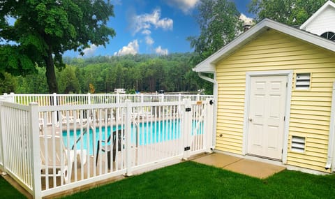 Heated swimming pool with fence and chairs to relax in.