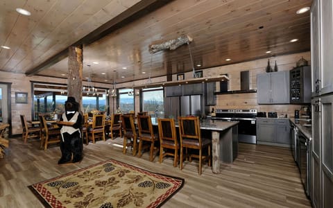 Open kitchen flows into a rustic dining area, accented by a charming bear butler.