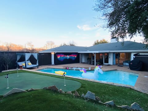 Patio with daybed, glow in dark mural, mini golf, heated pool and grill