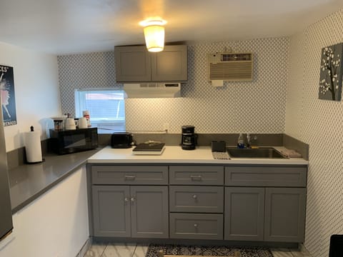 Kitchen with electric stove, utensils, coffee mkr, toaster & large mini fridge