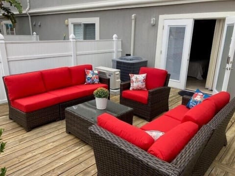 - Unwind on the private deck featuring bold red cushioned seating, rattan frames, and a matching coffee table
- Perfect for evening chats, reading under the sun, or a group hangout
- Access this inviting outdoor lounge directly from the bedroom