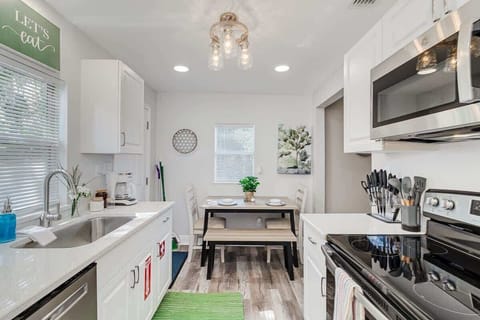 Natural light makes for cheerful mornings in this fully equipped eat-in kitchen  Cook healthy meals with ease using the stove and microwave. Perfect for culinary enthusiasts and families alike, ensuring a comfortable and enjoyable stay! 