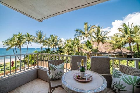 A serene lanai setting framed by lush tropical greenery creates a perfect spot for morning coffee or sunset relaxation.