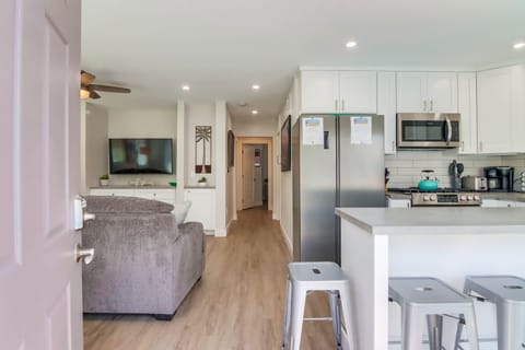 Entryway view to living and kitchen. Sliding glass door opens to patio. 