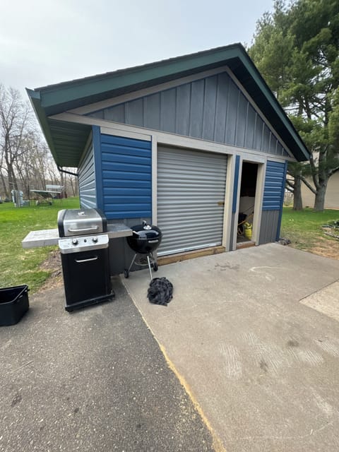 Shed with lawn games, grill and additional lawn chairs.