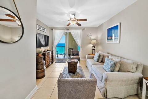 Your bright living room opens to a private balcony where ocean views greet you through flowing curtains.