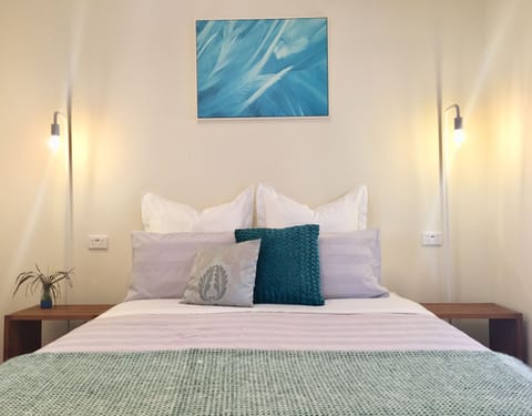 Queen bed, Lux Linens, Bedside Tables, Lamps, Phone Charger port, Clothing Rack.