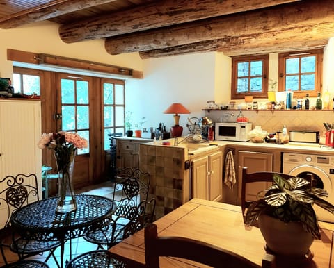 Open-plan kitchen with gas oven (gaziniere), microwave and washing machine.