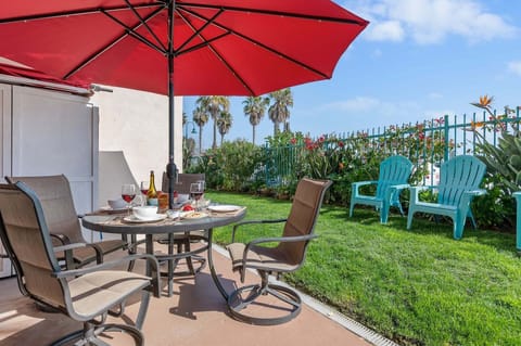 Furnished patio with table, chairs and umbrella. You can take the chairs onto the grass and enjoy the breeze off the beach.