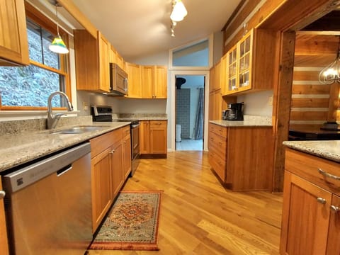 The fully stocked modern kitchen includes a dishwasher and granite counters.