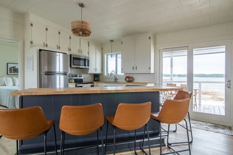 Newly renovated kitchen. All new stainless steel appliances. Butcher block bar that seats 5, plus table that seats 4. Walk out to the covered back porch with seating for a meal on the lagoon.