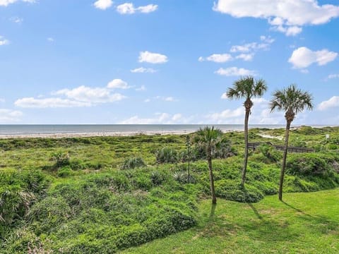 Lush garden leading to a serene beach, perfect for relaxing walks.