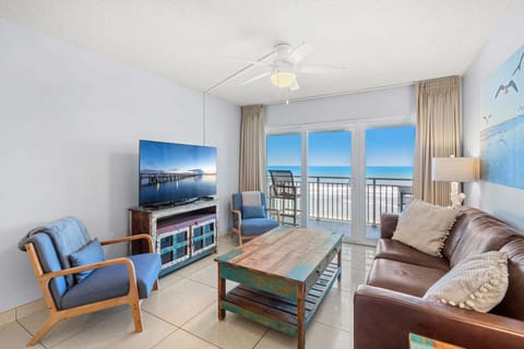 Imagine sinking into the plush blue sofa, feeling the ocean breeze drift in as the waves crash outside