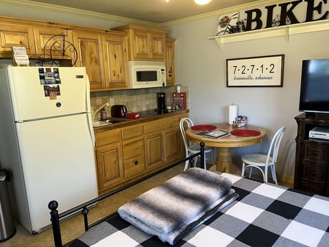 View of kitchenette from sleeping area. Full size fridge, microwave, cooktop.