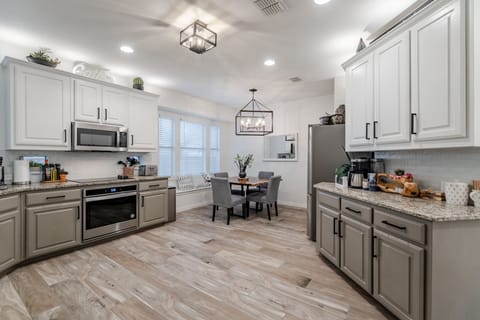 Kitchen stocked with appliances, pots and pans, dishes, utensils, and spices