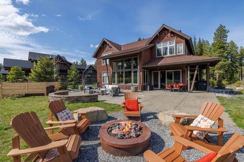 Twilight patio with gas firepit, cozy seating, and dramatic timber-frame