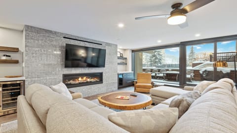 Sink into plush seating by your modern fireplace, with mountain views and snowy slopes visible through floor-to-ceiling windows—your perfect alpine retreat awaits.