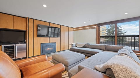 Sink into plush sectional seating by your cozy fireplace while enjoying mountain views through oversized windows—your perfect retreat after a day of adventure.