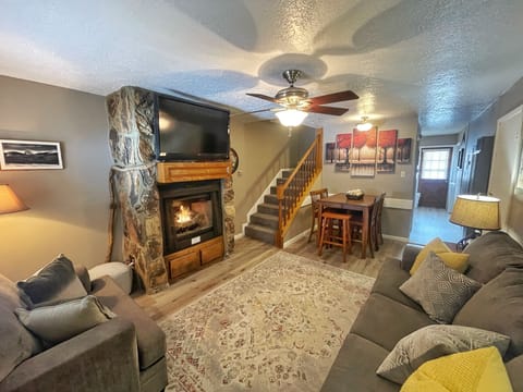 Curl up on plush sofas around a crackling fireplace, where warm lighting and rustic stone accents create your perfect mountain retreat after a day of adventure.
