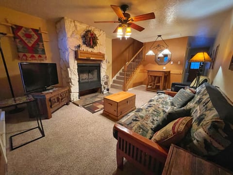 Unwind in your cozy living room with a stone fireplace, plush sofa, and rustic décor that invites you to relax after a day of adventure.