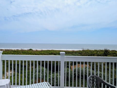 289B Bunting Ave, Fenwick Island - Ocean Front Deck - An expansive, wide-angle view from the top balcony showcasing the sandy beach, coastal dunes, and the Atlantic Ocean under a clear sky.