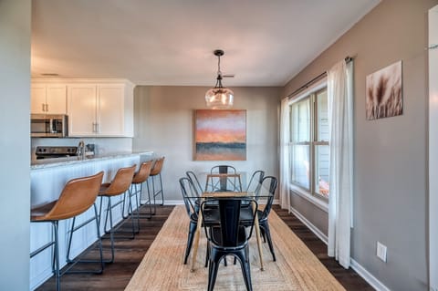 Dining table situated between kitchen and deck with view of dunes and ocean.