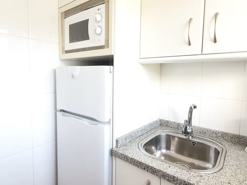 There is a fridge, microwave, hob, toaster.../ Hay un frigorífico, vitrocerámica, microondas, tostadora...