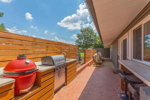 Outdoor Kitchen - Partially covered kitchen sited on the front of the home extends the living spaces outdoors, and features all new appliances—including both a gas grill and Kamado Joe egg grill. Bar-stool seating.