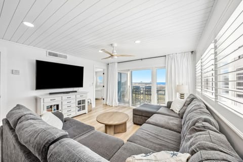 Unwind in your spacious living room with plush sectional seating, modern entertainment center, and stunning ocean views from every window.