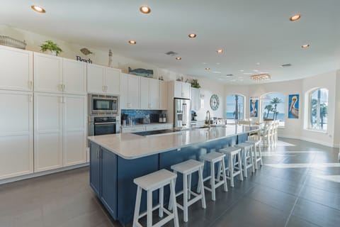 This modern kitchen features sleek finishes & calming blues & seats 8.