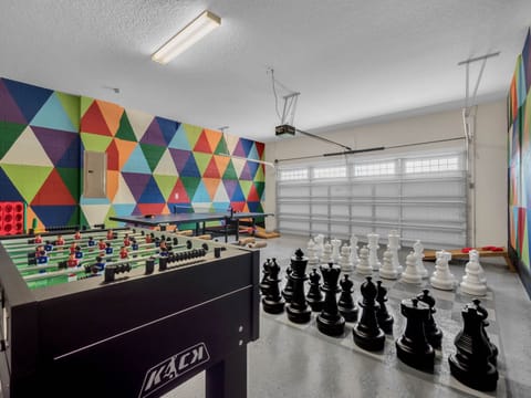 - Vibrant game room with foosball table and ping pong for endless entertainment  
- Giant chess set brings interactive fun for kids and adults alike  
- Colorful mural walls create a playful atmosphere for vacation rentals