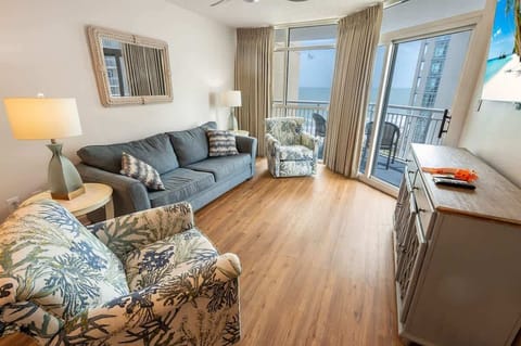 - Relax in the bright living room with ocean view seating   - Comfortable sofa and armchairs perfect for family stays   - Large windows bring in natural light and coastal charm