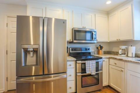 The renovated kitchen with stainless steel appliances, granite counters & white cabinets is located on the second floor.