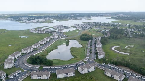 9405 Pettinaro Drive - Aerial Community View - High-angle aerial view of the Bethany Bay neighborhood and surrounding waterways, showcasing the layout of the community pond and nearby homes.