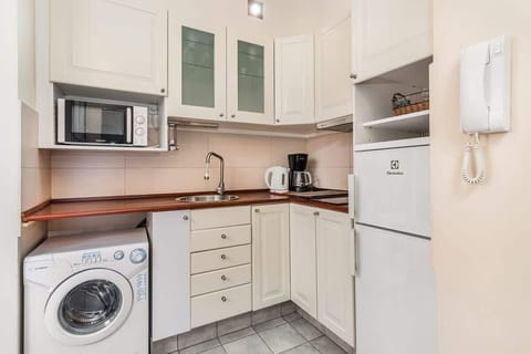 Compact kitchen with all essential appliances, including a washing machine and microwave for convenience.