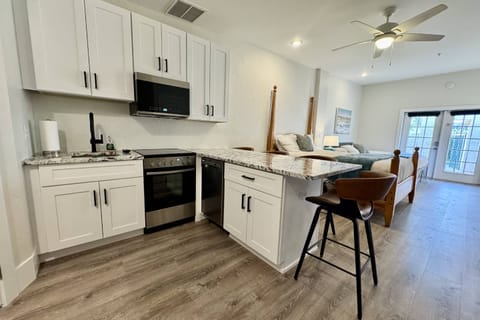 An updated kitchen - apartment size amenities includes a sink, microwave, dishwasher and oven/stove combo.