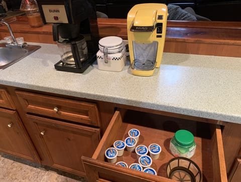 Two coffee makers with complementary supplies.