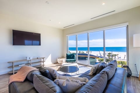 Living room with a luxurious leather couch, TV and views from every angle of the room.